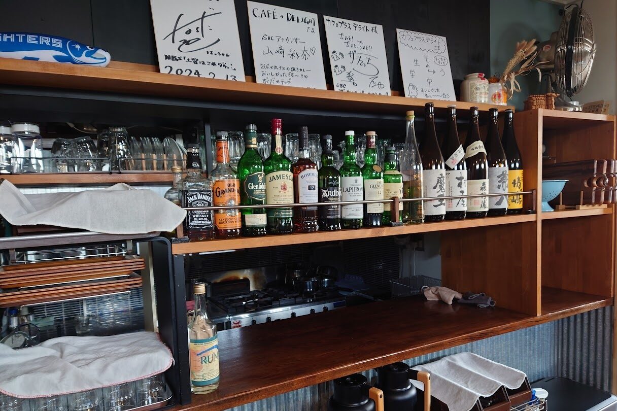 小布施Cafe+ DelightのBar Timeカウンター。魔王・森伊蔵・村尾（3M）などの焼酎と、アードベッグ・ラフロイグなどの本格ウイスキーが並ぶ店内