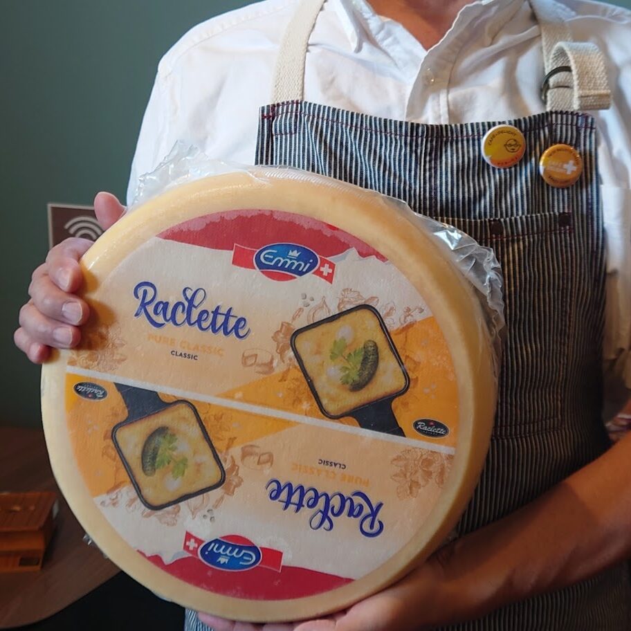本場スイス・エミ社（Emmi）の巨大なラクレットチーズホールを持つ店主